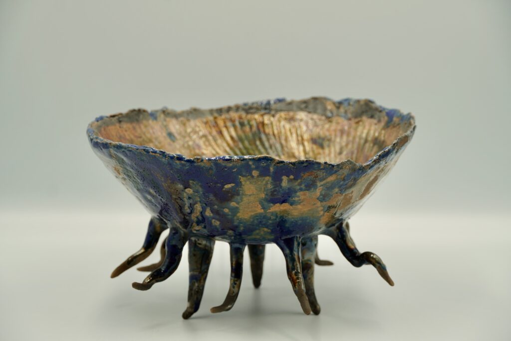 Taça de cerâmica artesanal com interior dourado, exterior azul e pés ramificados