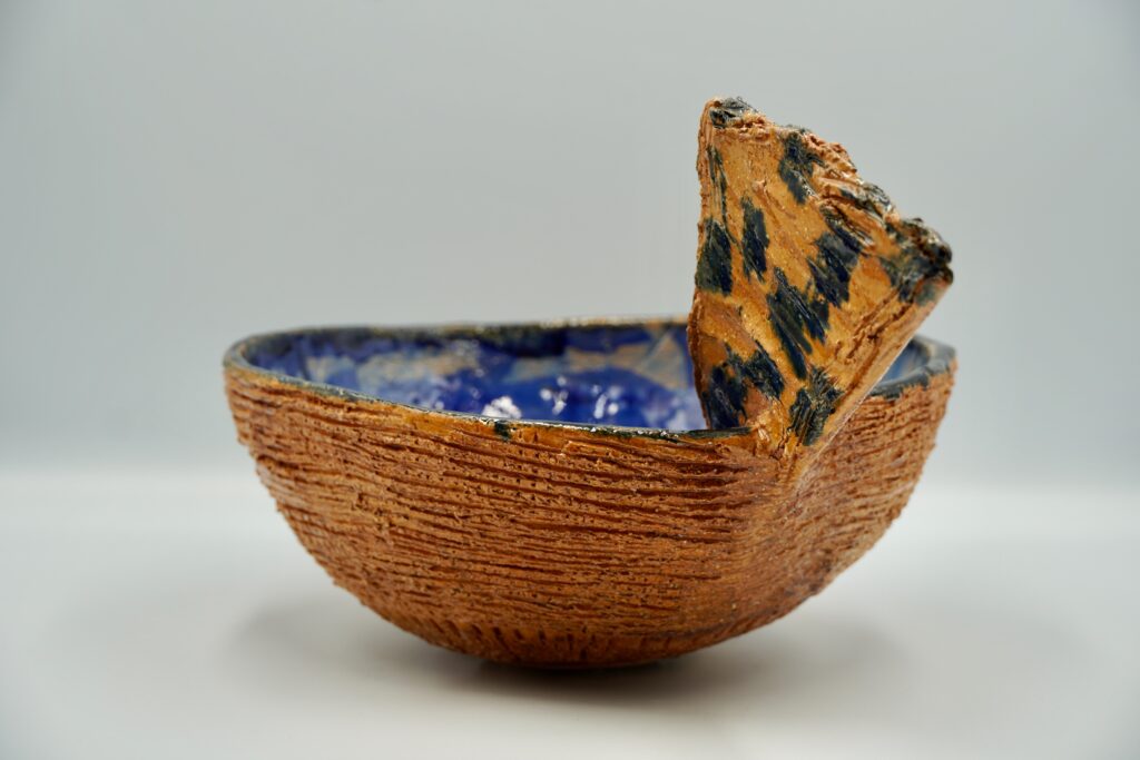 Taça de cerâmica artesanal com exterior alaranjado e interior azul